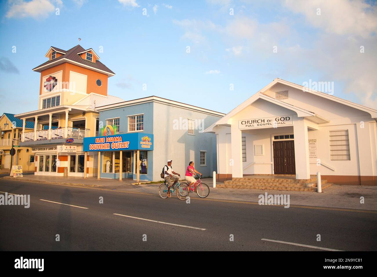 Unternehmen und Radfahrer am Wasser in George Town, Cayman Islands; George Town, Grand Cayman Islands, Cayman Islands Stockfoto