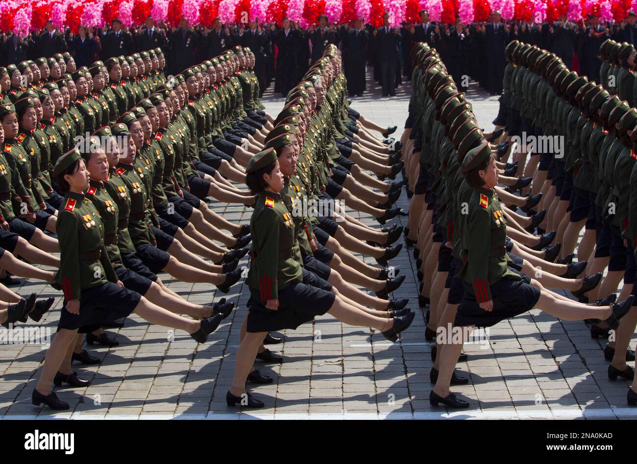 North Korean soldiers march in front of flower waving civilians during a mass military parade in Pyongyang's Kim Il Sung Square to celebrate 100 years since the birth of the late North Korean founder Kim Il Sung on Sunday, April 15, 2012. North Korean leader Kim Jong Un delivered his first public televised speech Sunday, just two days after a failed rocket launch, portraying himself as a strong military chief unafraid of foreign powers during festivities meant to glorify his grandfather, North Korea founder Kim Il Sung. (AP Photo/David Guttenfelder) Stockfoto