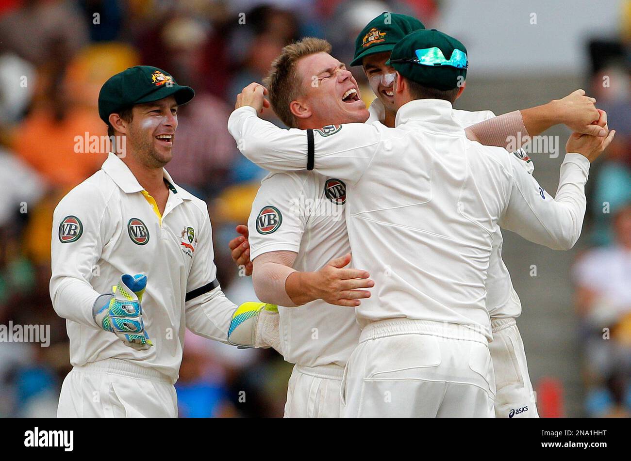 Australia's David Warner, center left, celebrates with teammates after catching and bowling out West Indies' batsman Kirk Edwards for 61 runs on the opening day of their first cricket Test match in Bridgetown, Barbados, Saturday April 7, 2012. (AP Photo/Andres Leighton) Stockfoto