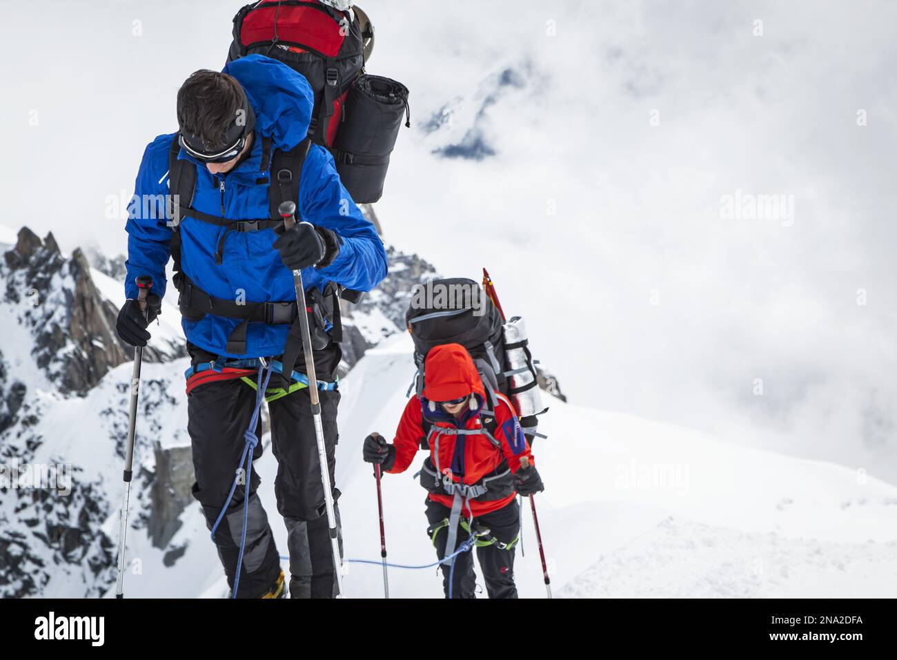 Kletterer mit Ausrüstung auf einem schneebedeckten Hügel, Aiguille du Midi, Chamonix - Mont Blanc, Alpen, Frankreich, Europa, Sommer. Stockfoto