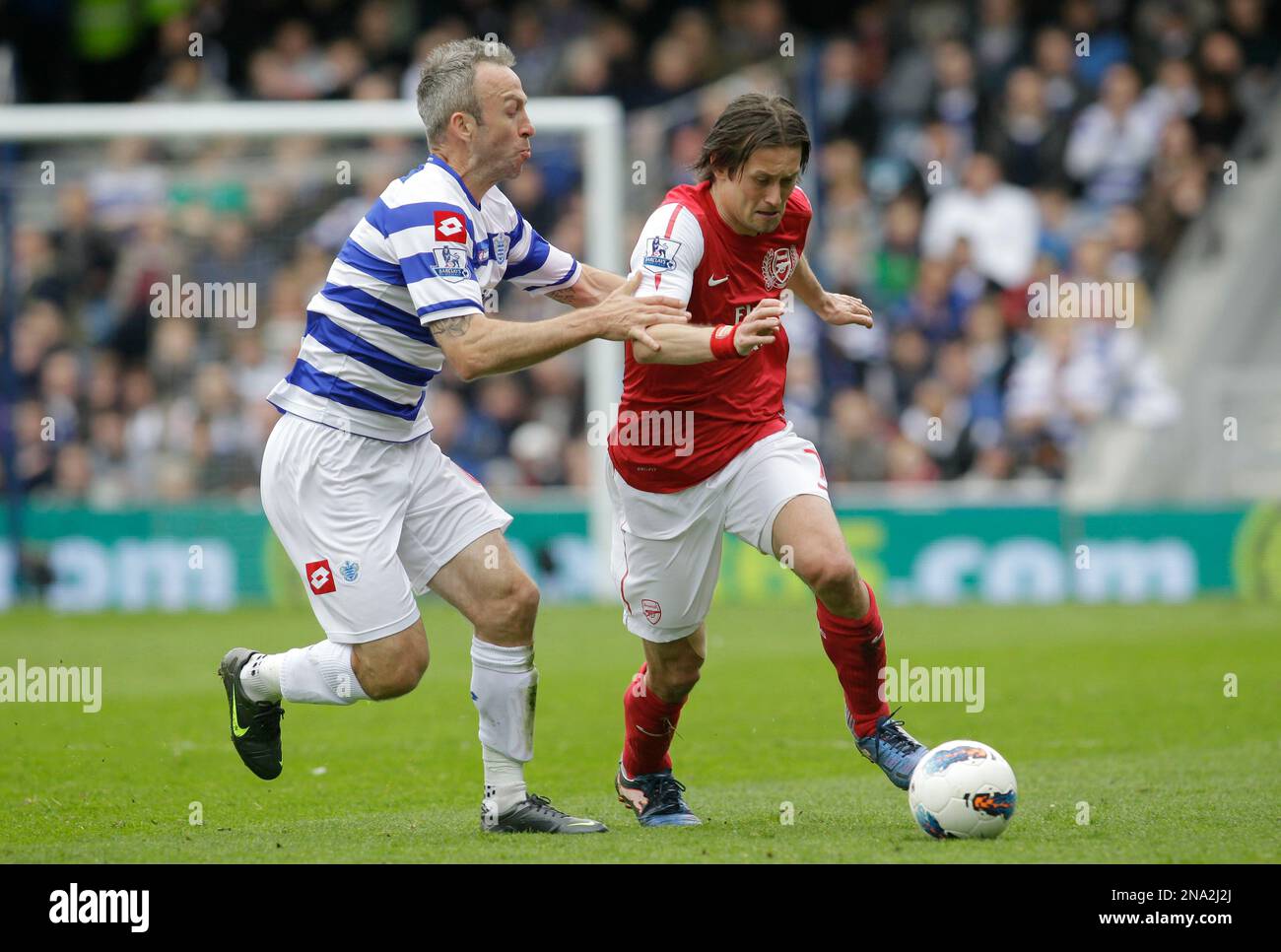 Queens Park Rangers' Shaun Derry, left, competes with Arsenal's Tomas Rosicky during their English Premier League soccer match at Loftus Road stadium, London, Saturday, March 31, 2012. (AP Photo/Sang Tan) Stockfoto
