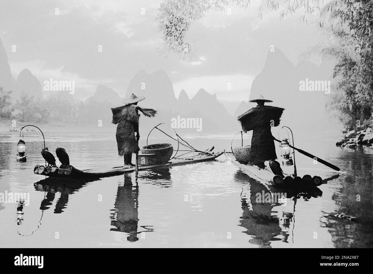 Schwarz-weiß-Bild von Fischern, die auf Booten auf einem ruhigen Fluss im Nebel mit Karstformationen in der Ferne stehen; China Stockfoto