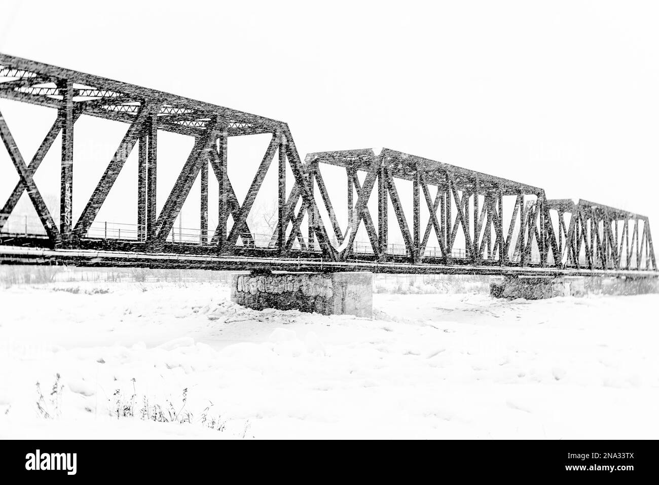 Schwarz-weiß-Foto einer Stahlzugbrücke, Wintersturm, Calgary Alberta Stockfoto