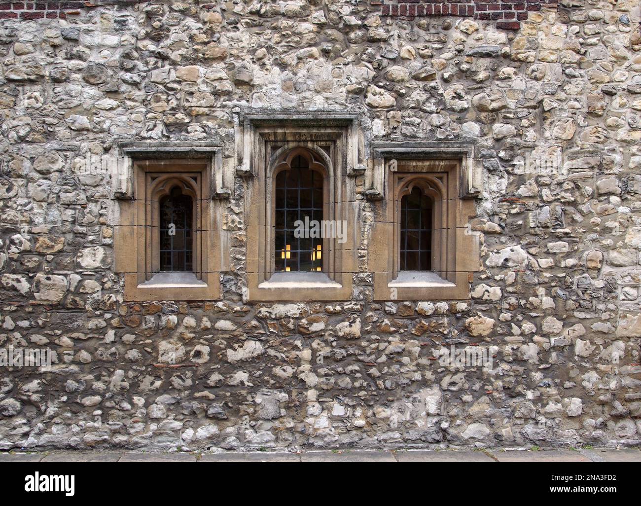 Alte abgenutzte Steinfassade um einige Fenster der Westminster School in London, die aus dem Mittelalter stammt Stockfoto