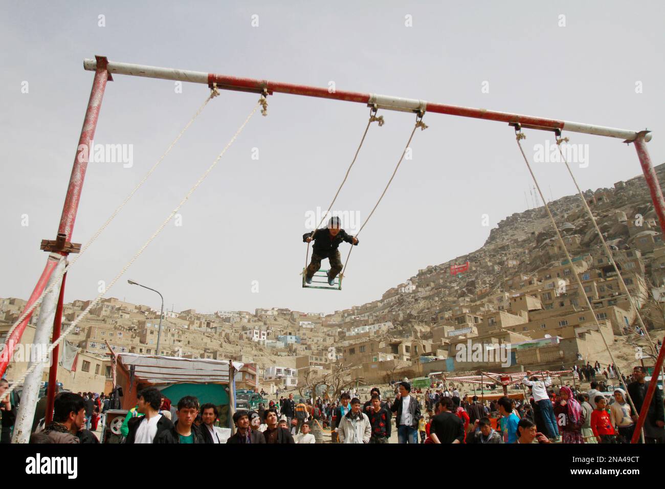 An Afghan boy swings during a celebration of the Persian New Year