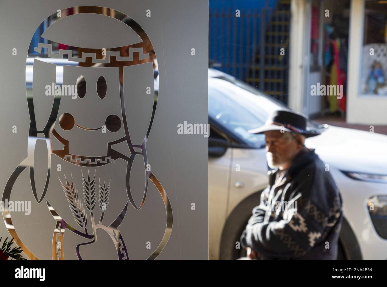 Lateinamerikanische Kunst in Glas geätzt, während ein älterer Mann vorbeigeht; Lota, Biobio, Chile Stockfoto