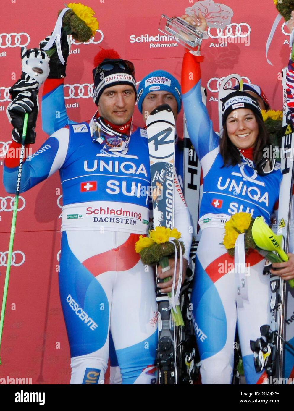 Switzerland's Silvan Zurbriggen celebrates with teammate Wendy Holdner after their team took second place in Schladming, Austria, Friday, March 16, 2012. The Austrian team, defeating Switzerland 3 - 1, has won the nations team event at the World Cup finals Friday for the first time since 2008. (AP Photo/Armando Trovati) Stockfoto