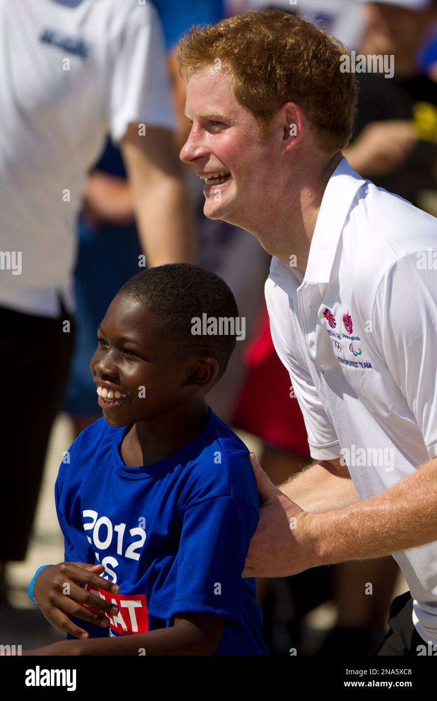 Britain's Prince Harry, jokes as he plays rugby with kids at Flamengo's beach in Rio de Janeiro, Brazil, Saturday March 10, 2012. Harry is in Brazil at the request of the British government on a trip to promote ties and emphasize the transition from the upcoming 2012 London Games to the 2016 Olympics in Rio de Janeiro. (AP Photo/Felipe Dana) Stockfoto
