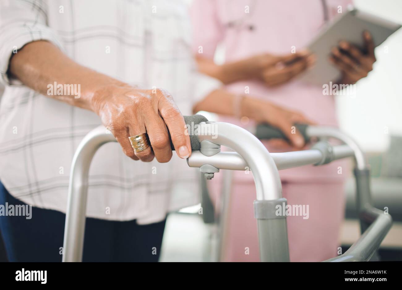 Die Zeit altert keine Legenden. Eine nicht erkennbare ältere Frau mit Gehhilfe und Gehhilfe eines Physiotherapeuten. Stockfoto