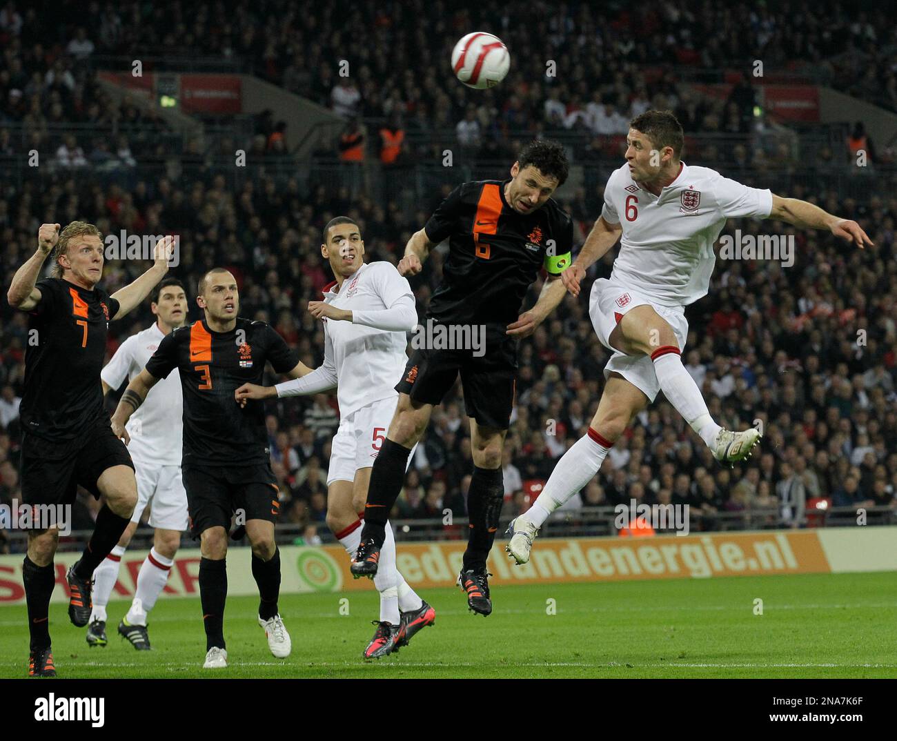 England's Gary Cahill, left, heads the ball towards goal under pressure from the Netherlands' Mark Van Bommel during their international soccer match at Wembley stadium in London Wednesday, Feb. 29, 2012. (AP Photo/Sang Tan) Stockfoto