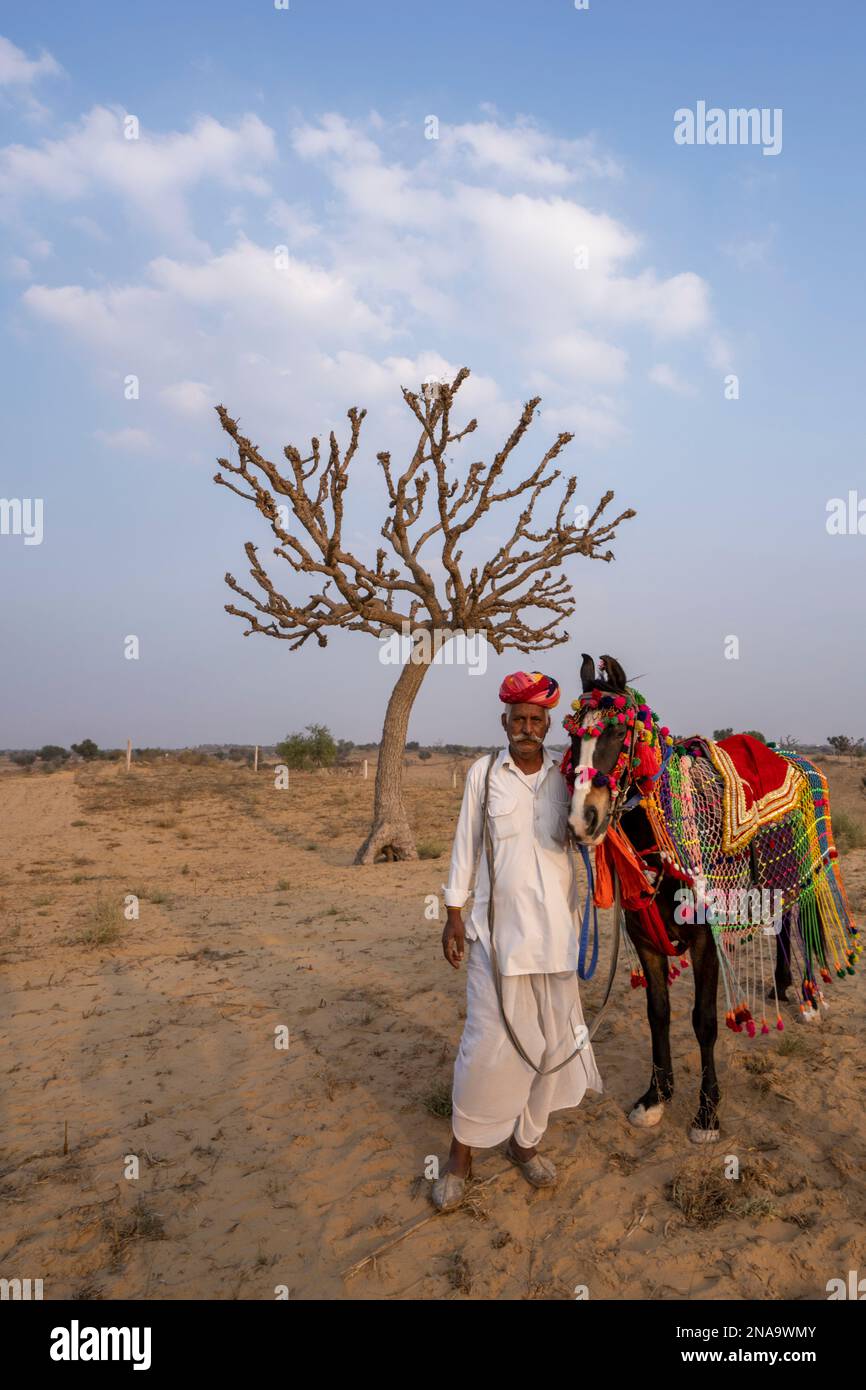 Rajput mit seinem Pferd in der Wüste Thar in Rajasthan, Indien; Nagaur, Rajasthan, Indien Stockfoto