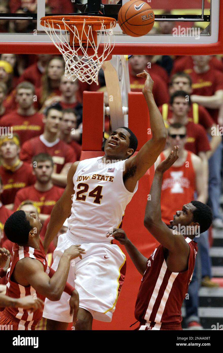 Iowa State center Percy Gibson (24) shoots over Oklahoma's Cameron Clark, left, and Andrew Fitzgerald, right, during the second half of an NCAA college basketball game, Saturday, Feb. 18, 2012, in Ames, Iowa. Iowa State won 80-69. (AP Photo/Charlie Neibergall) Stockfoto