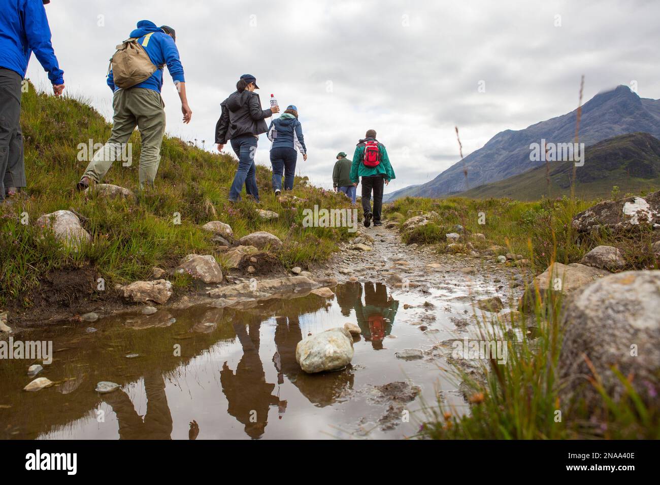Wanderer wandern entlang eines Bachs durch die Cuillin Mountains auf der Isle of Skye, Schottland. Stockfoto