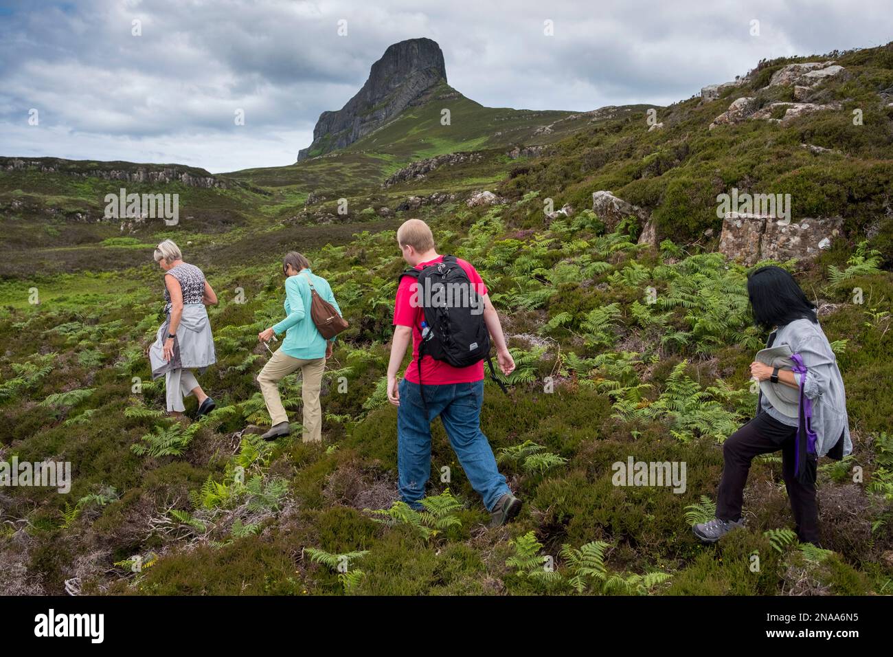 Wanderer navigieren auf einem Pfad in der Nähe eines Sgurr, Isle of Eigg, Schottland. Stockfoto