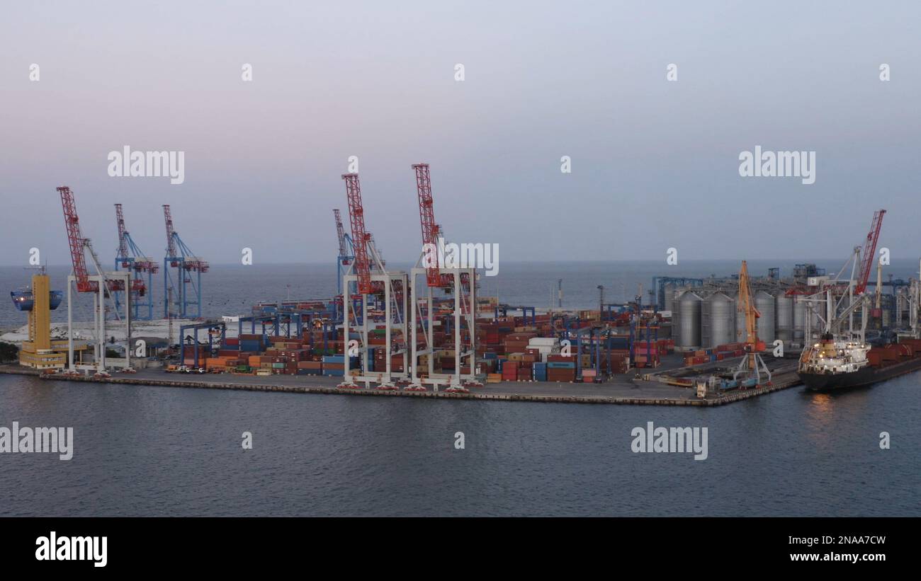 Odessa Seehafen mit Containern und Turmkränen. Getreideterminals und das Schiff. Abenddämmerung am Himmel. Stockfoto