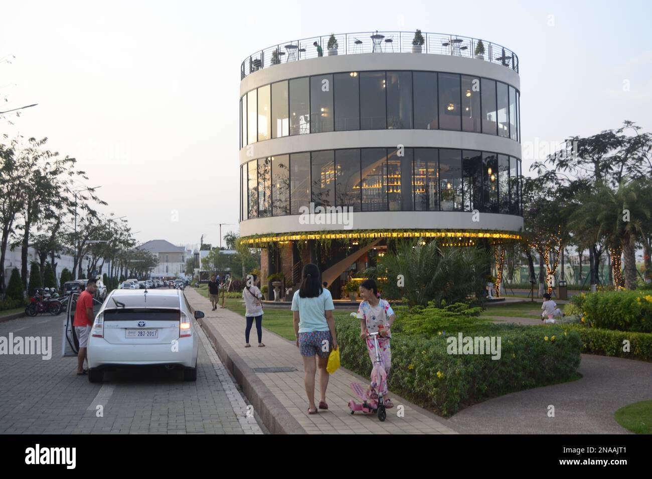 Familien auf abendlichem Spaziergang im kreisförmigen Restaurant Borey Peng Huoth, einem neuen Bauwerk in Phnom Penh, Kambodscha. Stockfoto