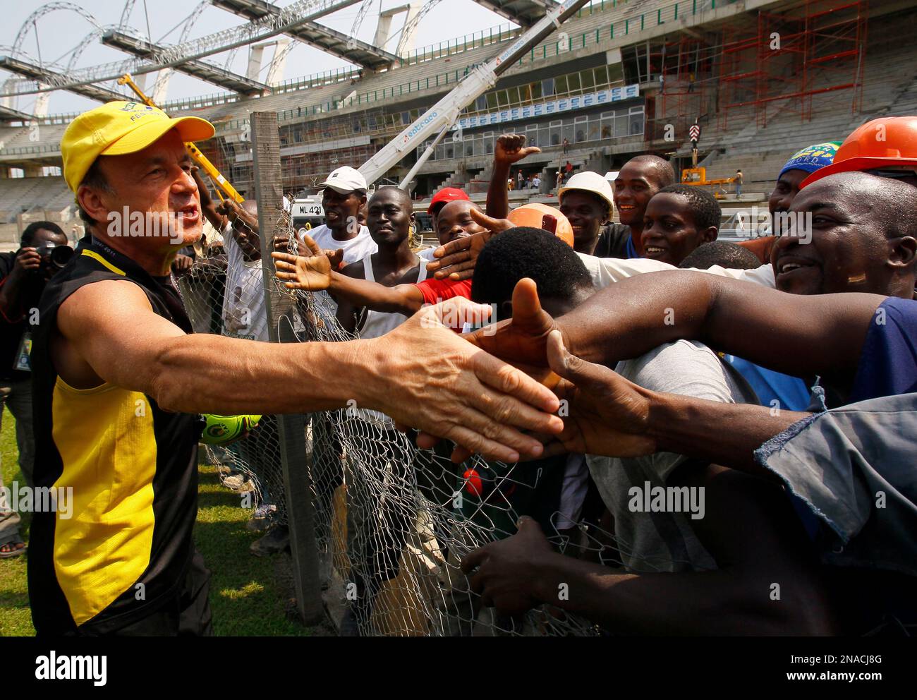 Gabon coach Gernot Rohr of Germany, left, greets workers at the Omnisport stadium during a training session ahead of their African Cup of Nations quarterfinal soccer match against Tunisia in Libreville, Gabon, Thursday, Feb. 2, 2012. (AP Photo/Francois Mori) Stockfoto