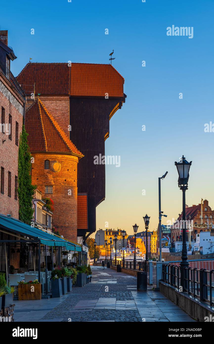 Mittelalterlicher Kran bei Sonnenaufgang auf der Long Embankment Flusspromenade in der Altstadt von Danzig in Polen, Symbol der Stadt. Stockfoto