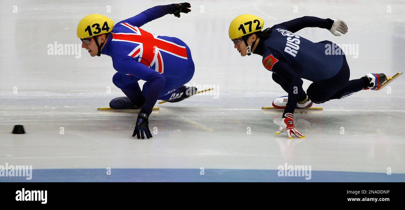 Vladimir Grigorev, right, from Russia and Jon Eley, left, from Great Britain compete during semifinal during the European Short Track Speed Skating championship in Mlada Boleslav, Czech Republic, on Saturday, Jan. 28, 2012. Grigorev won the race, Eley took third. (AP Photo/Petr David Josek) Stockfoto