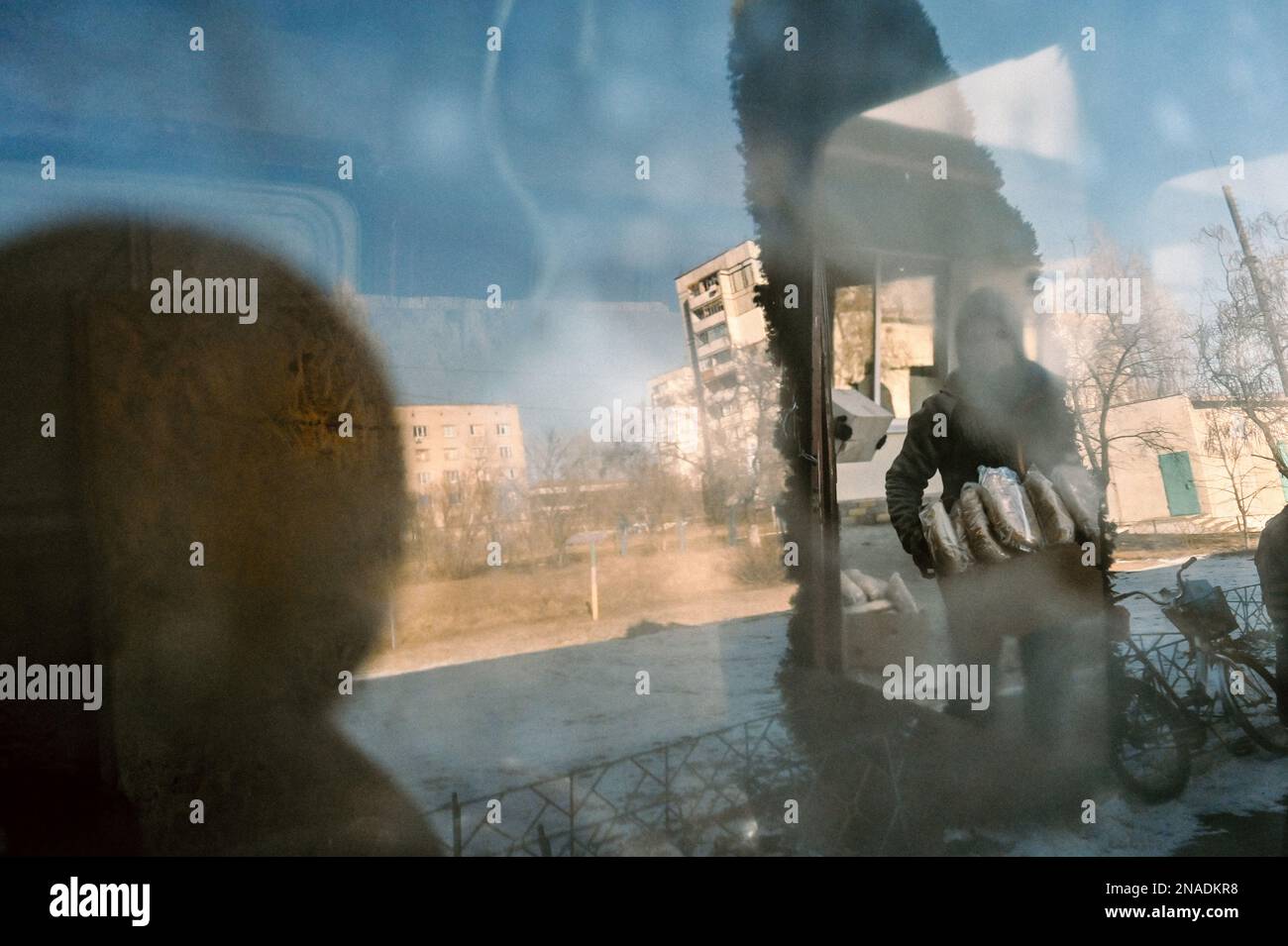 STEPNOHIRSK, UKRAINE - 9. FEBRUAR 2023 - Eine Person steht außerhalb eines Unbesiegbarkeitspunktes, wo die Einheimischen humanitäre Hilfe erhalten, Stepnohirsk, Stockfoto