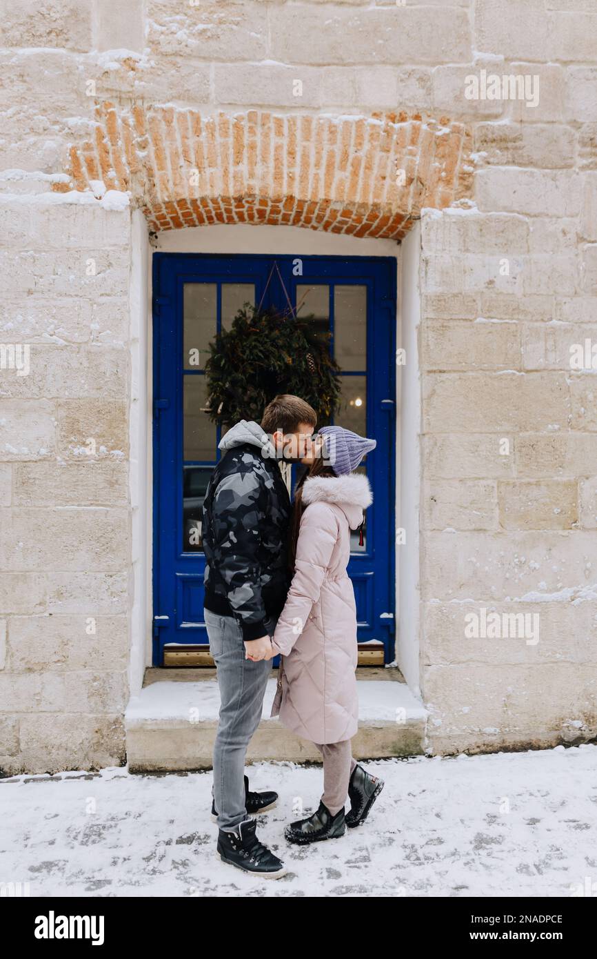 Ein verliebtes Paar küsst sich in einer verschneiten Winterstadt Stockfoto