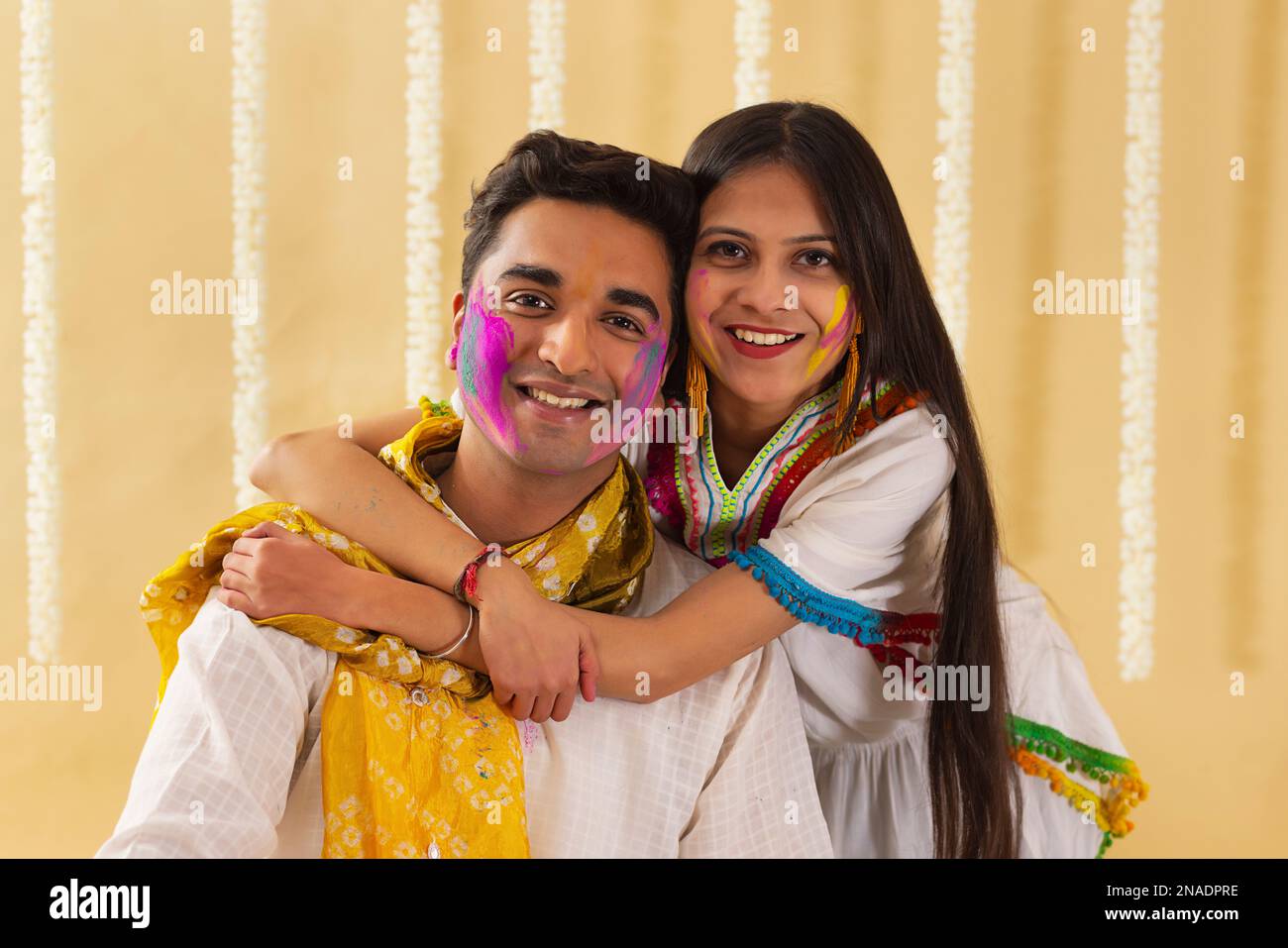 Eine junge Frau und ein Mann, die zusammen mit Gulal auf ihren Gesichtern posieren, während sie holi feiern Stockfoto