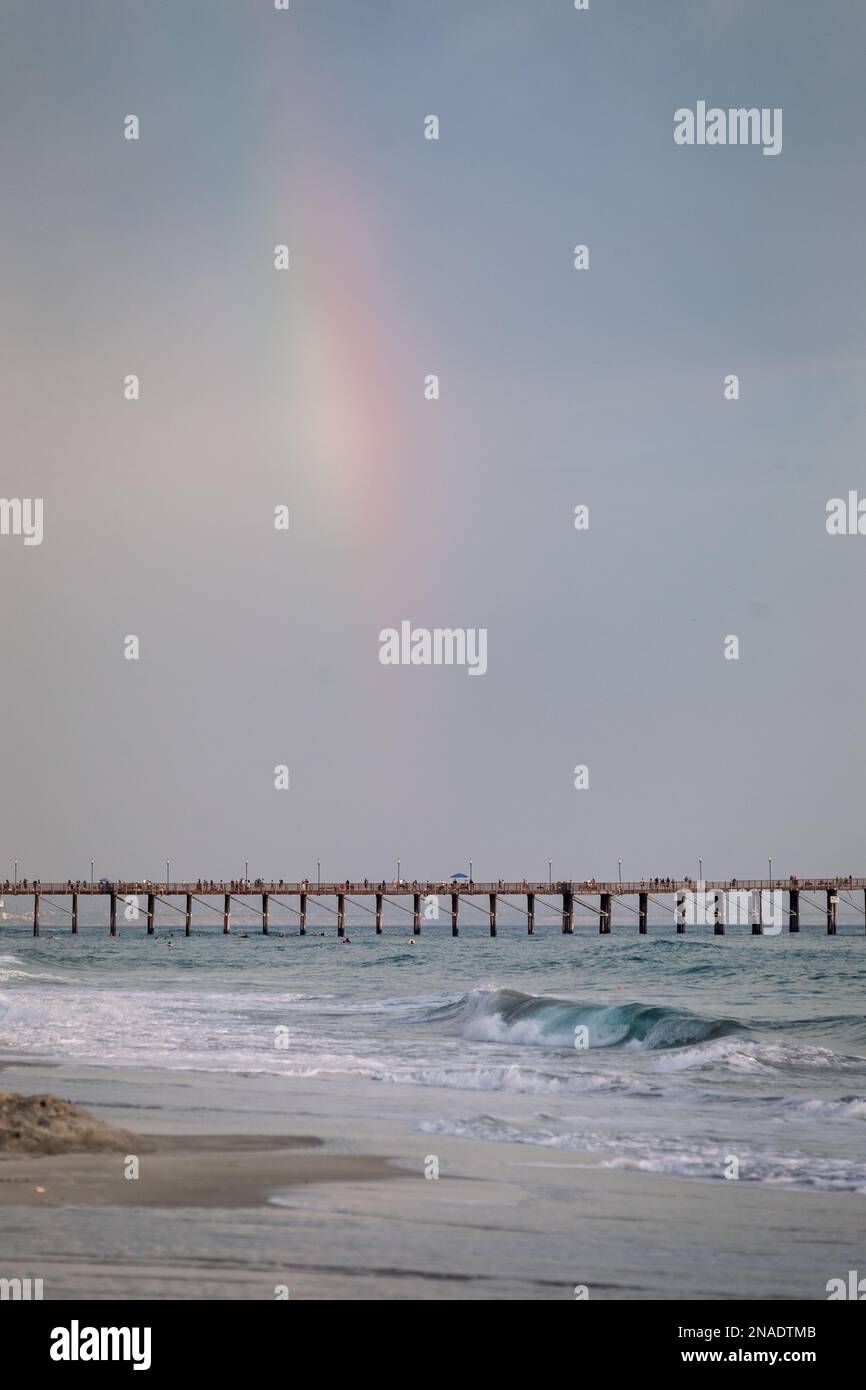 Regenbogen über dem Pier an einem stürmischen Strandtag in Oceanside Stockfoto