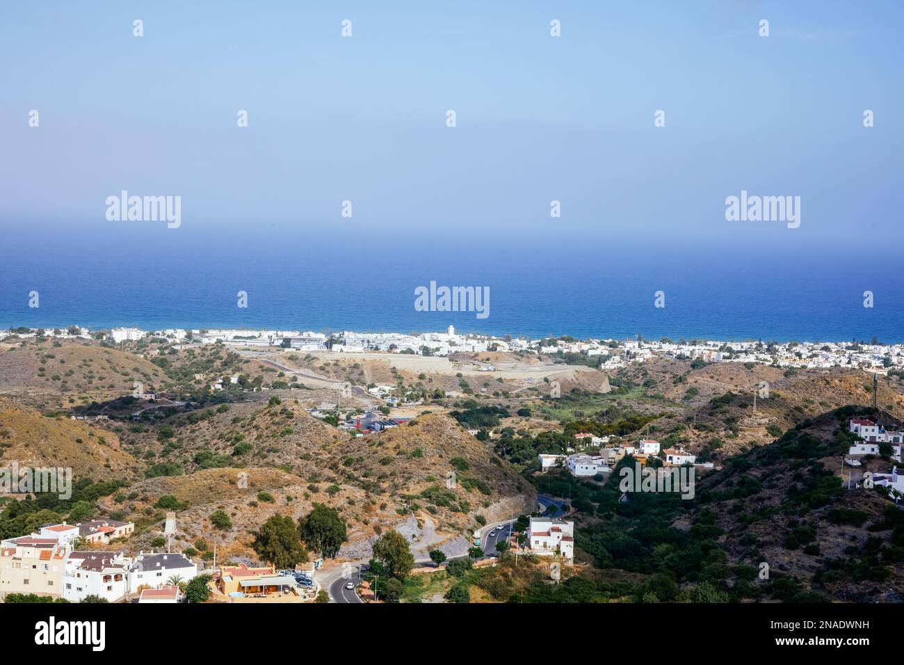 Blick auf ein weißes Dorf am Horizont vom Berg mit dem Meer im Hintergrund auf den Kanarischen Inseln. Stockfoto