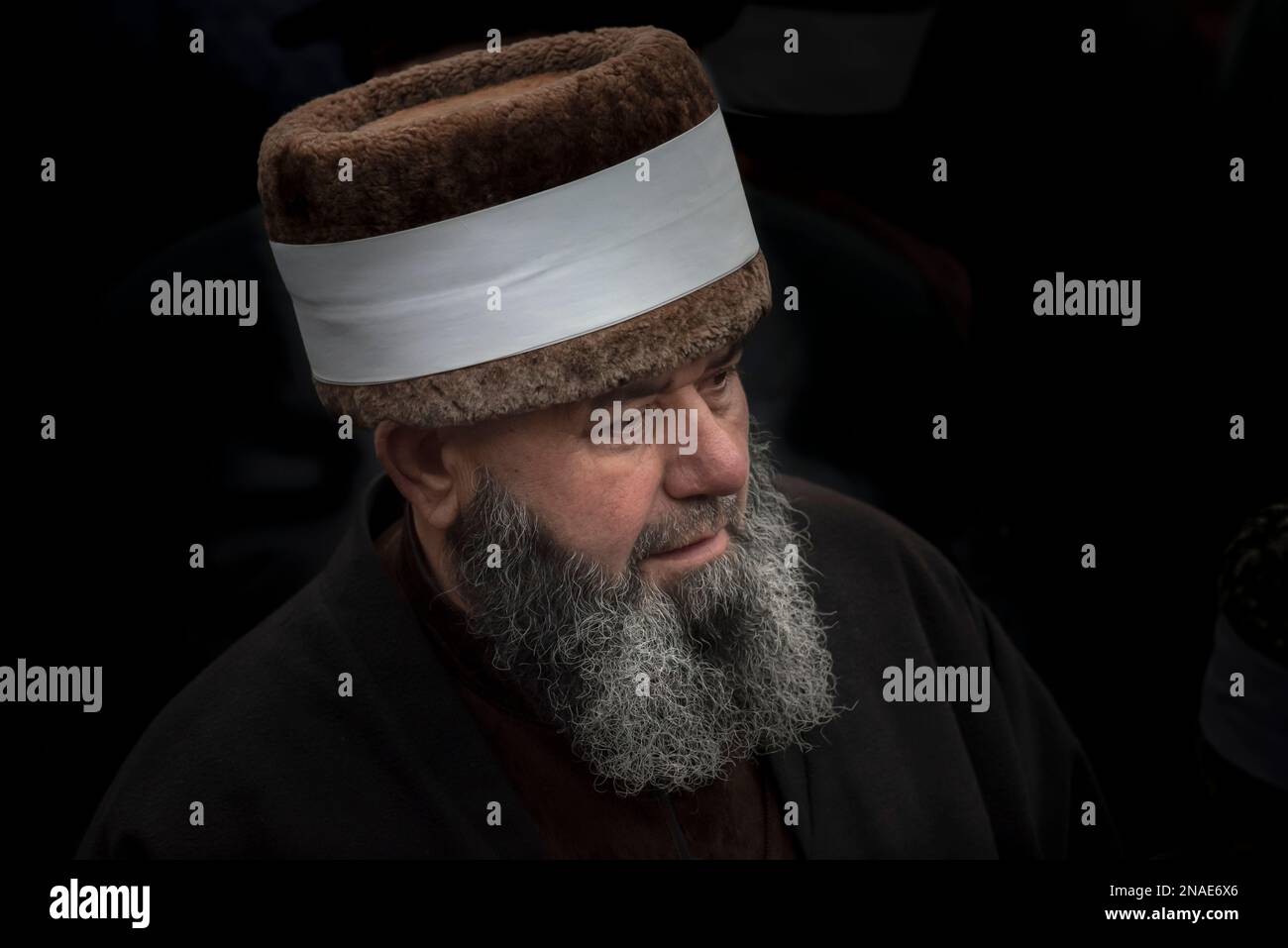 Porträt eines weißen Hut-Sufis vor schwarzem Hintergrund; Grosny, Tschetschenien, Russland Stockfoto