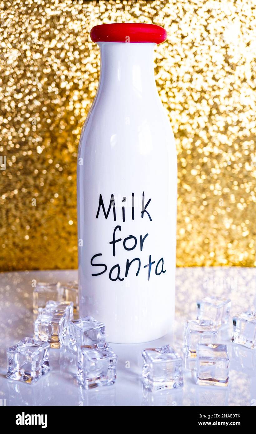 Milch für den Weihnachtsmann mit goldenem Hintergrund Stockfoto