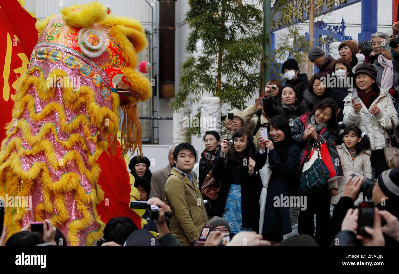 Chinese dragon dancers draw attention from onlookers as they celebrate the Chinese Lunar New Year, parading through China Town in Yokohama, one of the biggest in Japan, near Tokyo, Monday, Jan 23, 2012. (AP Photo/Koji Sasahara) Stockfoto