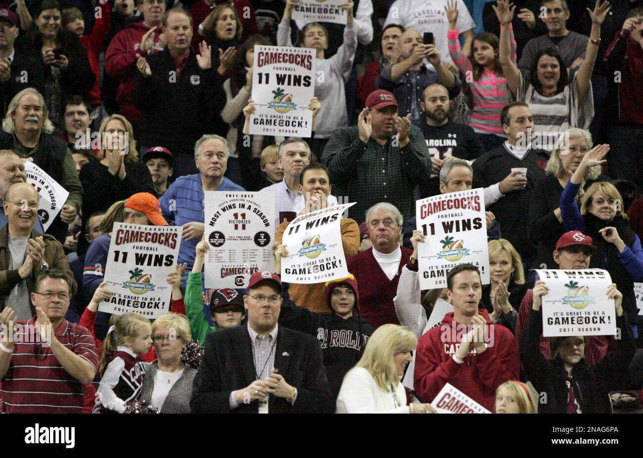 Fans hold up posters as the South Carolina football team is recognized during the halftime of an NCAA college basketball game between South Carolina and Florida, Saturday, Jan. 14, 2012, in Columbia, S.C. (AP Photo/Mary Ann Chastain) Stockfoto