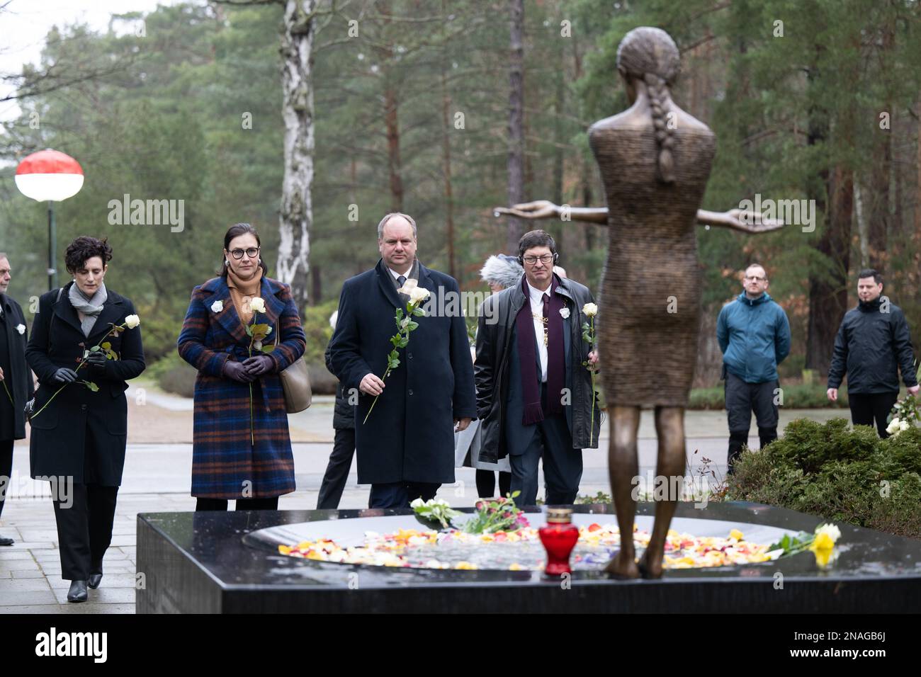 13. Februar 2023, Sachsen, Dresden: Natalie Toms (l-r), Chargé d'Affaires Britische Botschaft Berlin, Andrea Hoffmannova, stellvertretender Bürgermeister der Zwillingsstadt Ostrava, Dirk Hilbert (FDP), Oberbürgermeister von Dresden, Und Lord Mayor Kevin Maton, Lord Mayor aus der Zwillingsstadt Coventry, legte weiße Rosen auf die Bronzeskulptur "Trauermädchen" der polnischen Künstlerin Malgorzata Chodakowska auf dem Heide Friedhof. Am 13. Februar erinnert die Hauptstadt Dresden an die Zerstörung der Stadt während des Zweiten Weltkriegs vor 78 Jahren. Am 13. Und 14. Februar 1945 reduzierten die alliierten Bomber das Zentrum der Stadt auf der Elbe Stockfoto