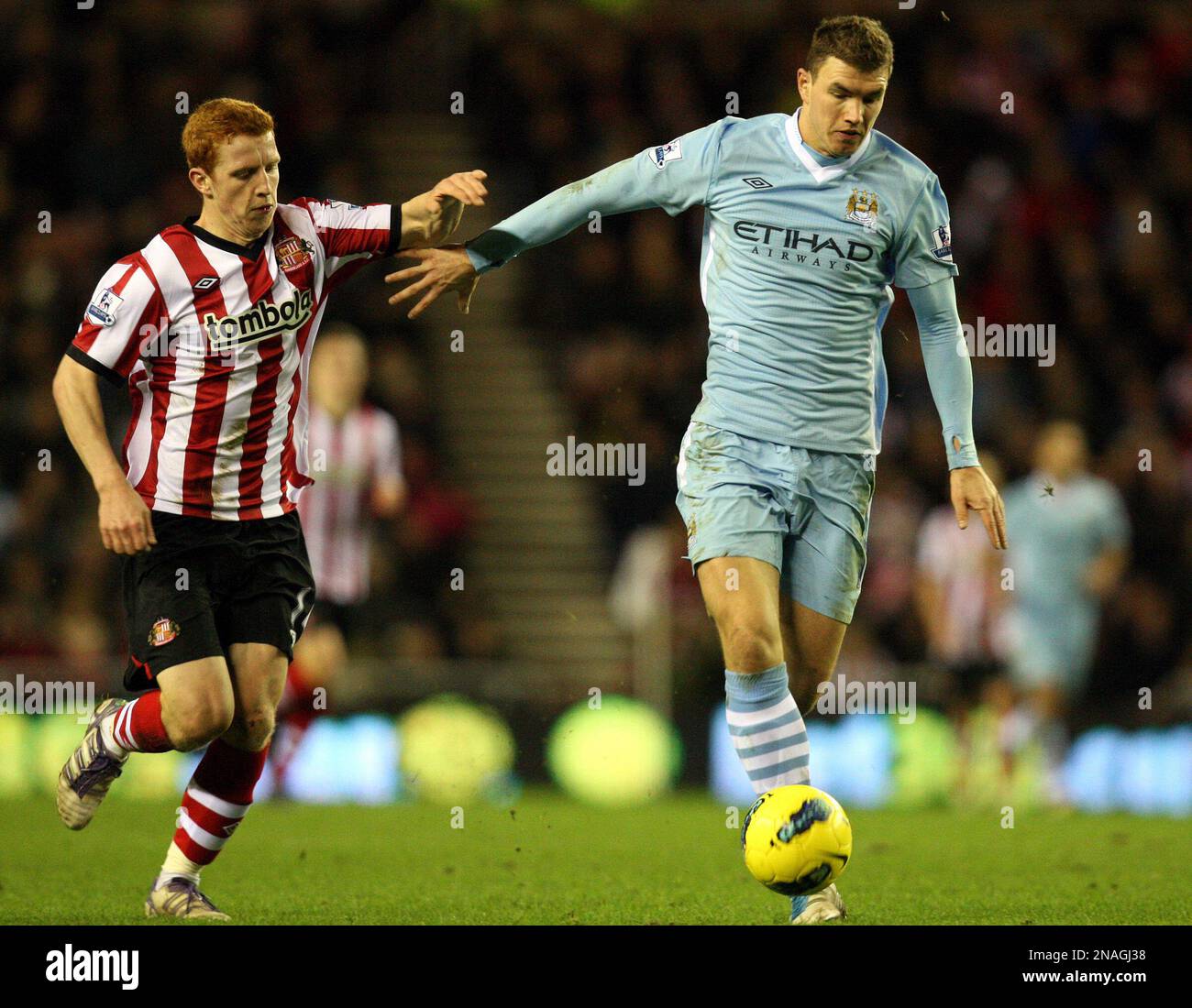 Manchester City's Edin Dzeko, right, vies for the ball with Sunderland ...