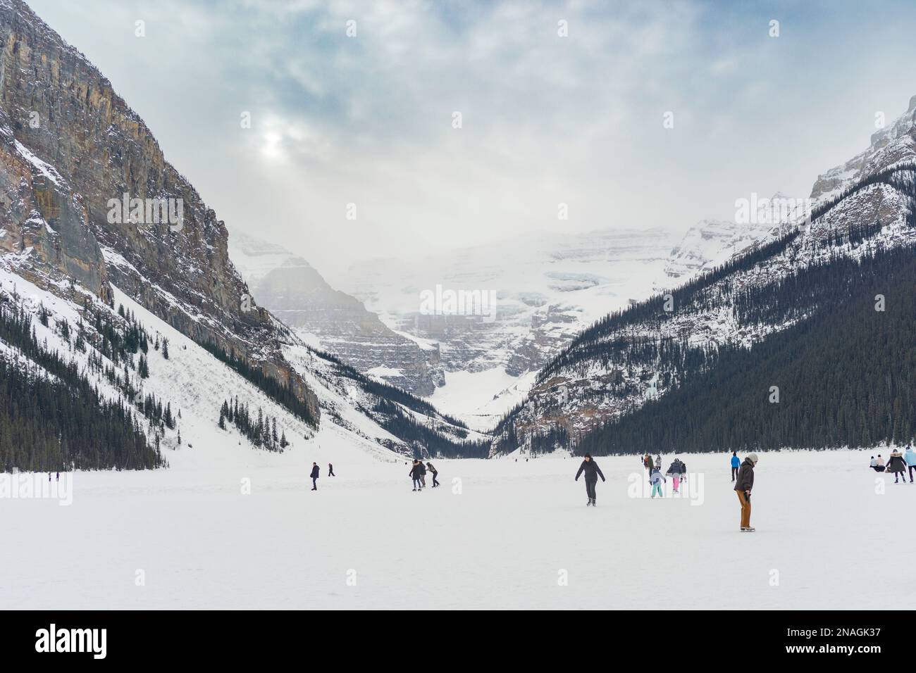 Touristen Schlittschuhlaufen und im Winter einen gefrorenen Lake Louise genießen, Banff National Park, Alberta, Kanada; Improvement District No. 9, Alberta, Kanada Stockfoto