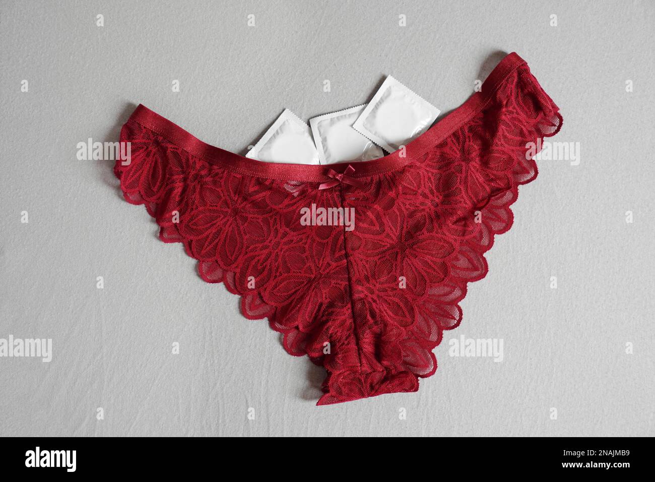 Rote Damenhöschen mit Kondomen - Sex und Empfängnisverhütung Konzept Stockfoto