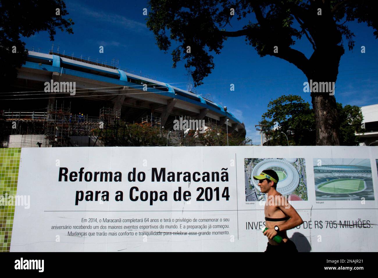 ADVANCE FOR USE WEEKEND OF DEC. 31-JAN 1 AND THEREAFTER- FILE - In this Dec. 21, 2011, file photo, a man runs by a sign that reads in Portuguese "Reform of Maracana for the 2014 World Cup" outside Maracana stadium in Rio de Janeiro. The Maracana, the second-most visited tourist destination in Rio, is to soccer what Yankee Stadium is to baseball, what Lambeau Field is to NFL football or what Madison Square Garden is to basketball. (AP Photo/Victor R. Caivano) Stockfoto