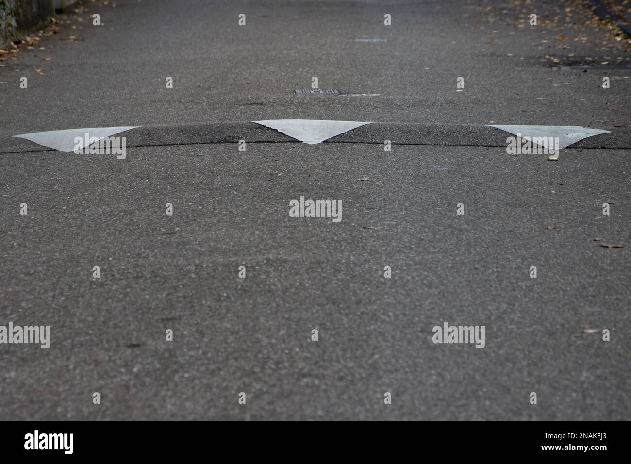 Weiße Diamant-Straßenmarkierung, um zu signalisieren, dass die Geschwindigkeit verringert wird Stockfoto