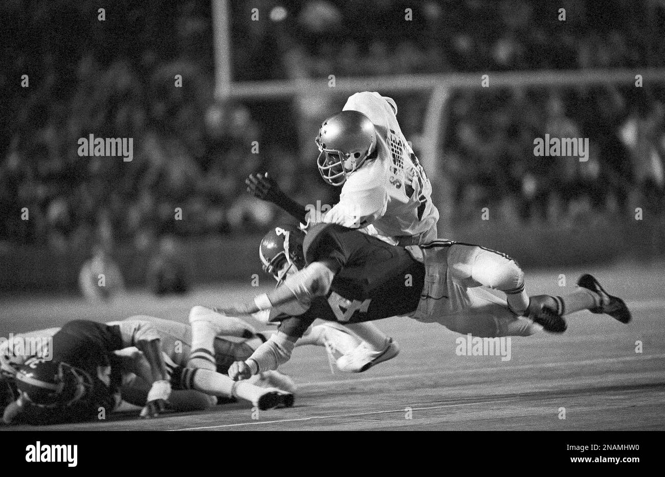 Alabama safety Alan Pizzitola (4) throws a diving tackle on Notre Dame’s halfback Al Samuel (24) as Samuel gains ground in the first period of the Orange Bowl game in Miami on Jan. 1, 1975. (AP Photo) Stockfoto