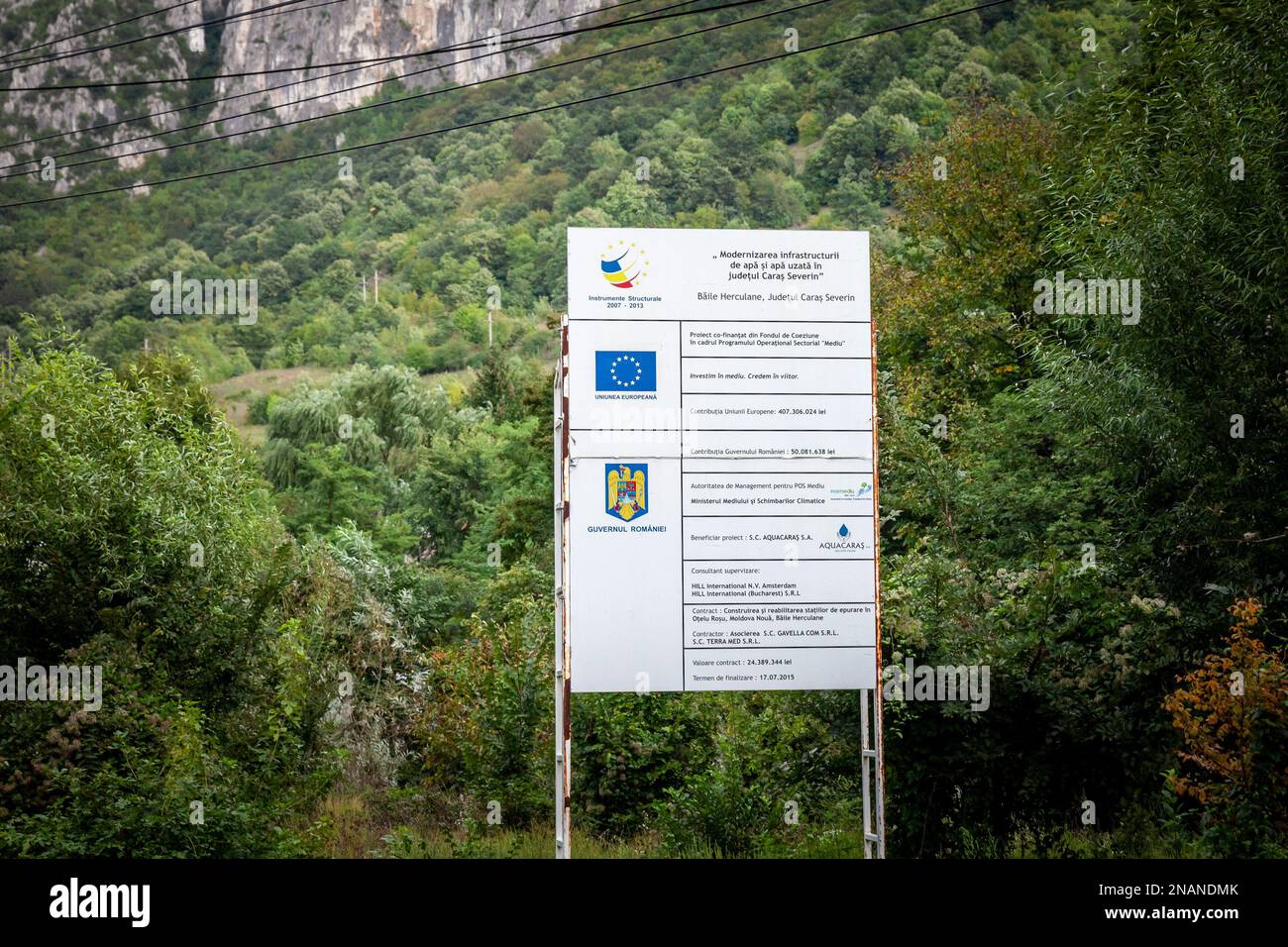 Bild eines Schildes, auf dem angegeben ist, dass ein Wiederaufbauprojekt von der rumänischen Regierung und der Europäischen Union in Rumänien, in Baile Herculane, finanziert wird. Stockfoto