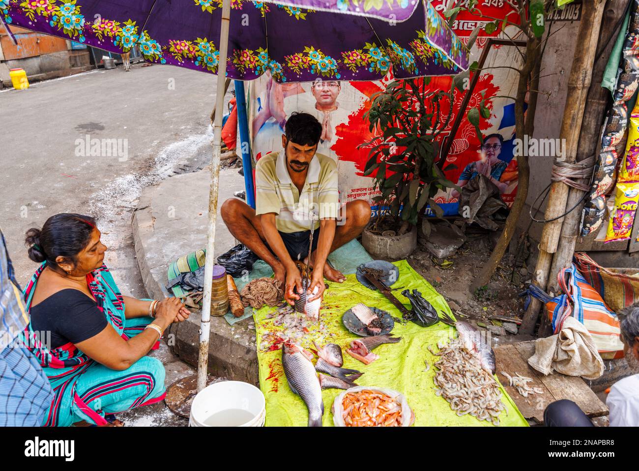 Lokale Straßenhalter schneiden, schneiden und bereiten Fisch für den Verkauf an einem Verkaufsstand in Fariapukur, Shyam Bazar, Kalkutta, Westbengalen, Indien Stockfoto