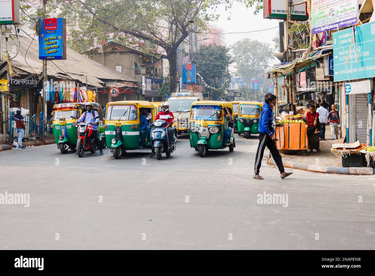 Straßenszene in Kanna, Shyam Bazar, Vorort Kalkutta, Westbengalen, Indien mit Autorickshaws (Tuktuks) Stockfoto