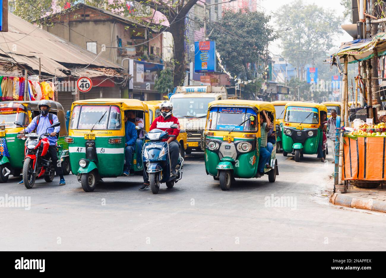 Straßenszene in Kanna, Shyam Bazar, Vorort Kalkutta, Westbengalen, Indien mit Autorickshaws (Tuktuks) Stockfoto