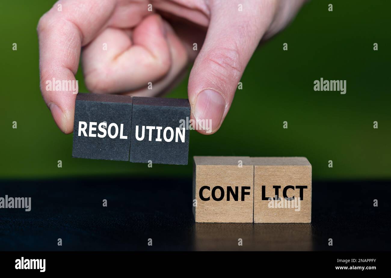 Wählt Holzwürfel mit der Hand mit dem Ausdruck „Auflösung“ statt Würfel mit dem Wort „Konflikt“ aus. Symbol zum Lösen eines Konflikts. Stockfoto