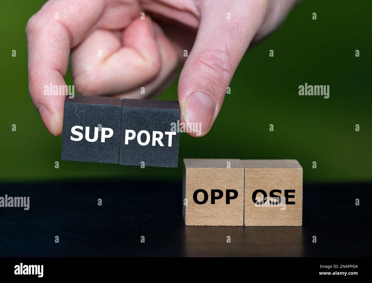 Mit der Hand werden Holzwürfel mit dem Wort Stütze anstelle von Würfeln mit dem Wort Oppose ausgewählt. Stockfoto