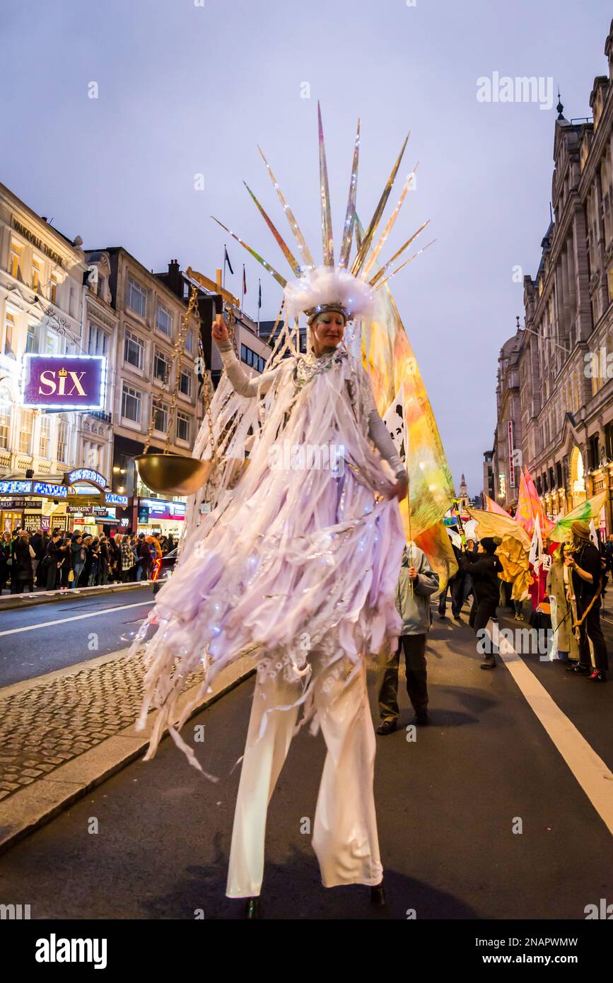 Die Anhänger von WikiLeaks, Gründer Julian Assange, imitieren die Freiheitsstatue mit einer Waage der Gerechtigkeit und fordern seine Verwandten mit einem „Night Carnaval“ Stockfoto