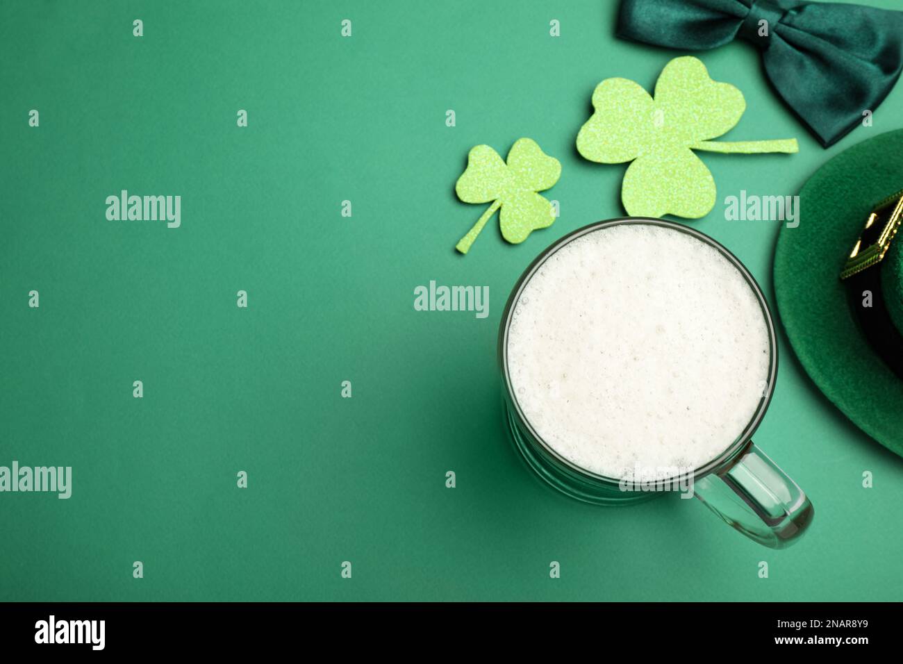Bier und St. Patrick's Day Dekor auf grünem Hintergrund, flach gelegen. Platz für Text Stockfoto
