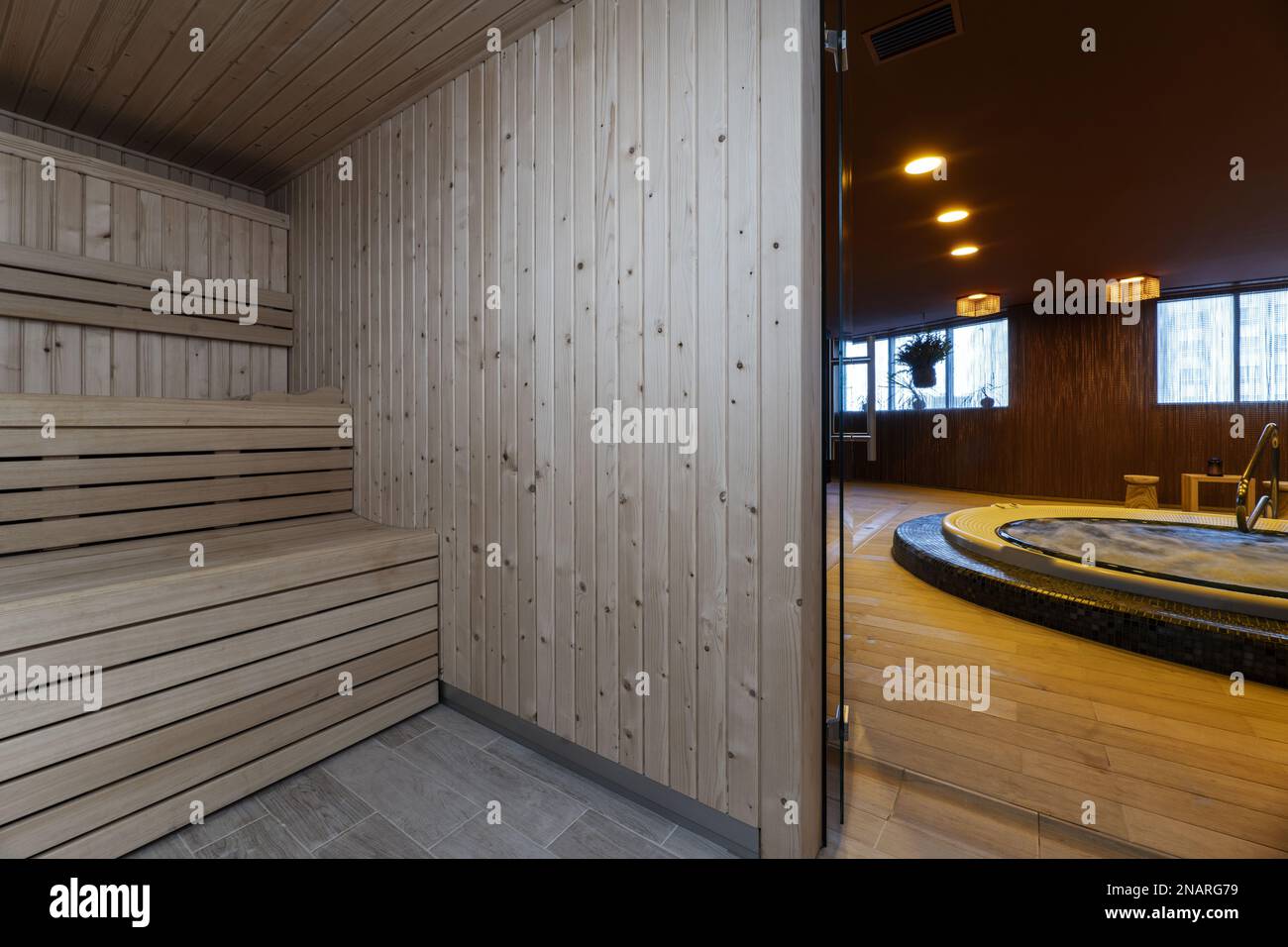 Eine finnische Sauna auf zwei Etagen, in der Sie sich bei einer schweißtreibenden Entspannung entspannen können, neben einem Whirlpool in einem therapeutischen Massagezentrum Stockfoto