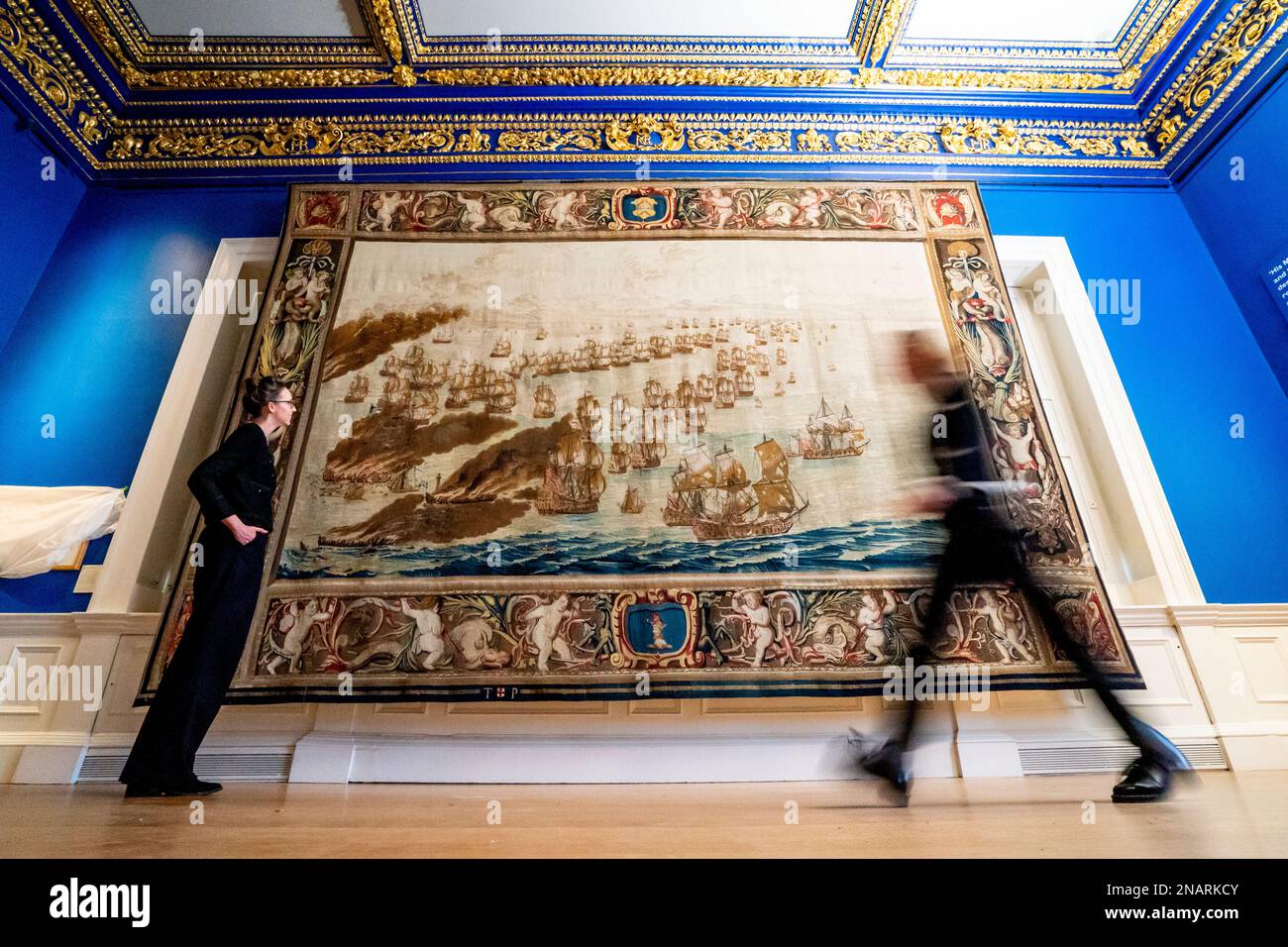 (Von links nach rechts) die Kuratoren Allison Goudie und Imogen Tedbury vom Queen's House beobachten den Solebay Tapestry, nachdem er in der Anwesenheitskammer des Königs im Queen's House in Greenwich, Süd-London, installiert wurde. Der Wandteppich ist das Hauptobjekt der bevorstehenden Ausstellung, The Van de Veldes: Greenwich, Art and the Sea. Foto: Montag, 13. Februar 2023. Stockfoto