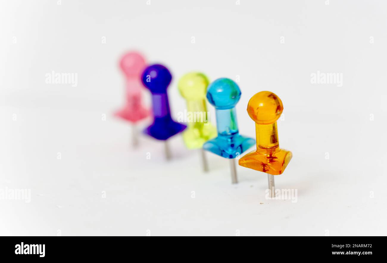 Viele farbenfrohe Stecknadeln auf weißem Farbkonzept. Stockfoto